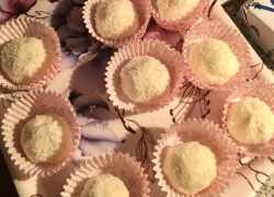Hotové kokosové guličky s mascarpone posypané kokosom v ružových košíčkoch