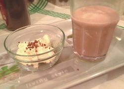 Ľadová káva v sklenenom pohári na tácke. V sklenenej mištičke je vanilková zmrzlina posypaná grankom.