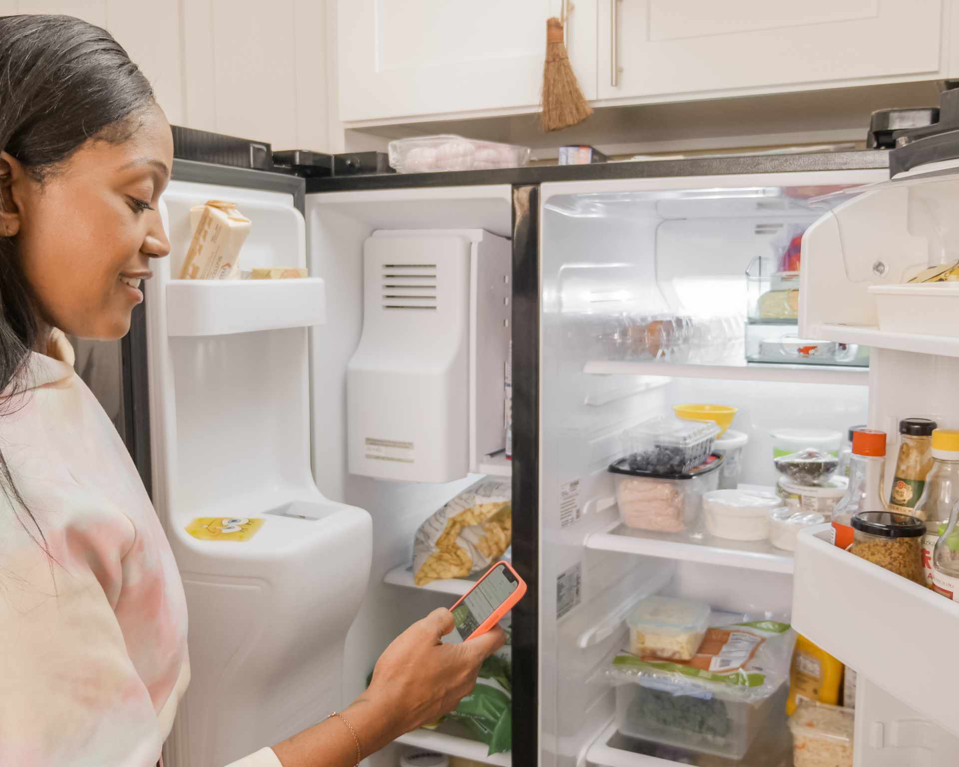 Žena stojí pred otvorenou chladničkou a rozmýšľa čo uvarí - hľadá čo chladnička dá