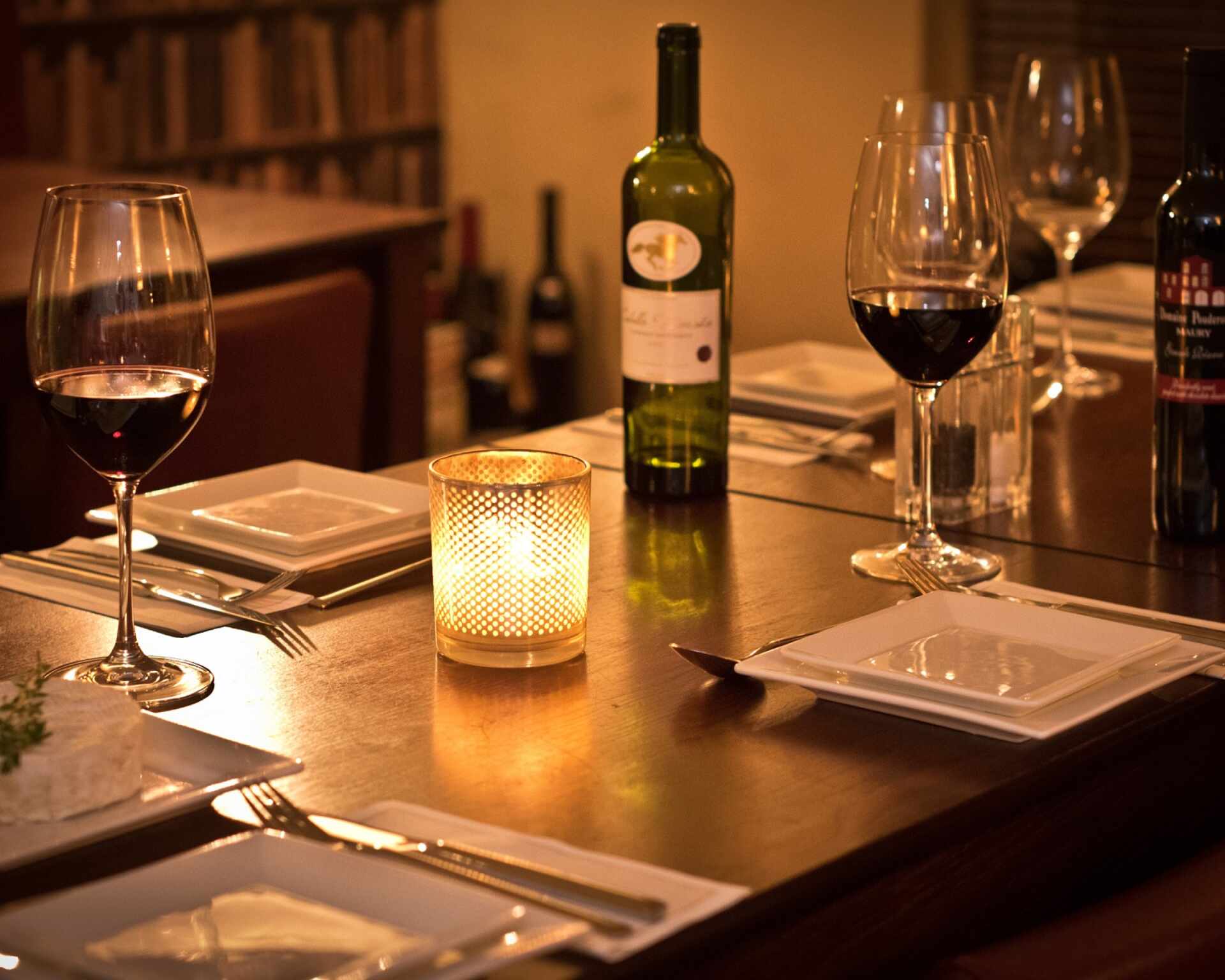 Vináreň s fľašou vína a pohármi na prestretom stole