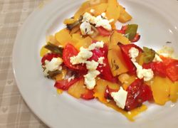 Oranžová tekvica upečená s paradajkami a paprikami s mäkkým bielym syrom