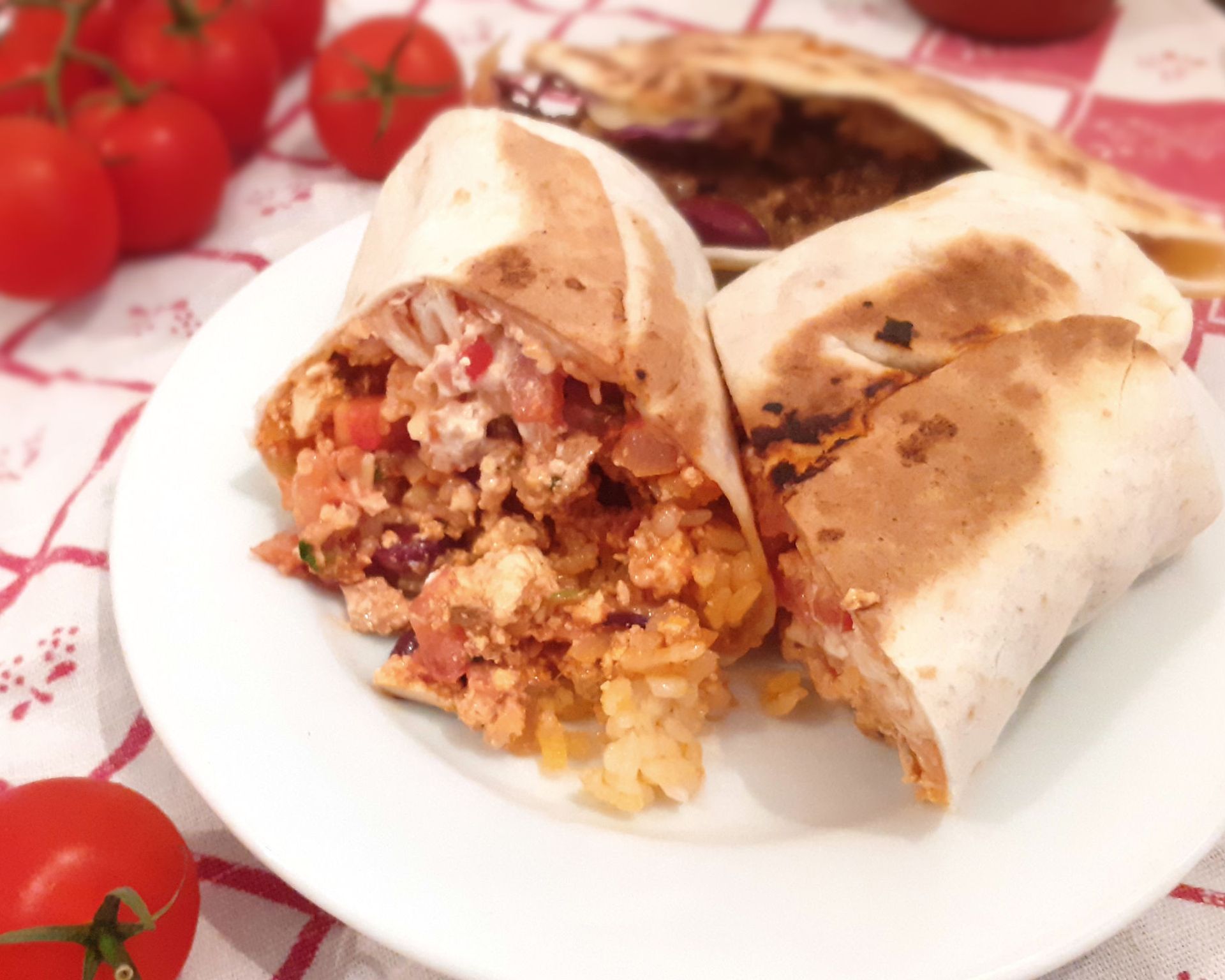 Tortilla prekrojená na polovicu plnená fazuľouv, ryžou, zeleninou a tofu