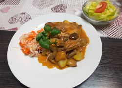 Hubové bravčové mäsko s omáčkou, varené zemiaky v šupke s mrkvovo-kapustovým šalátikom, v pozadí hlávkový šalát s paradajkou