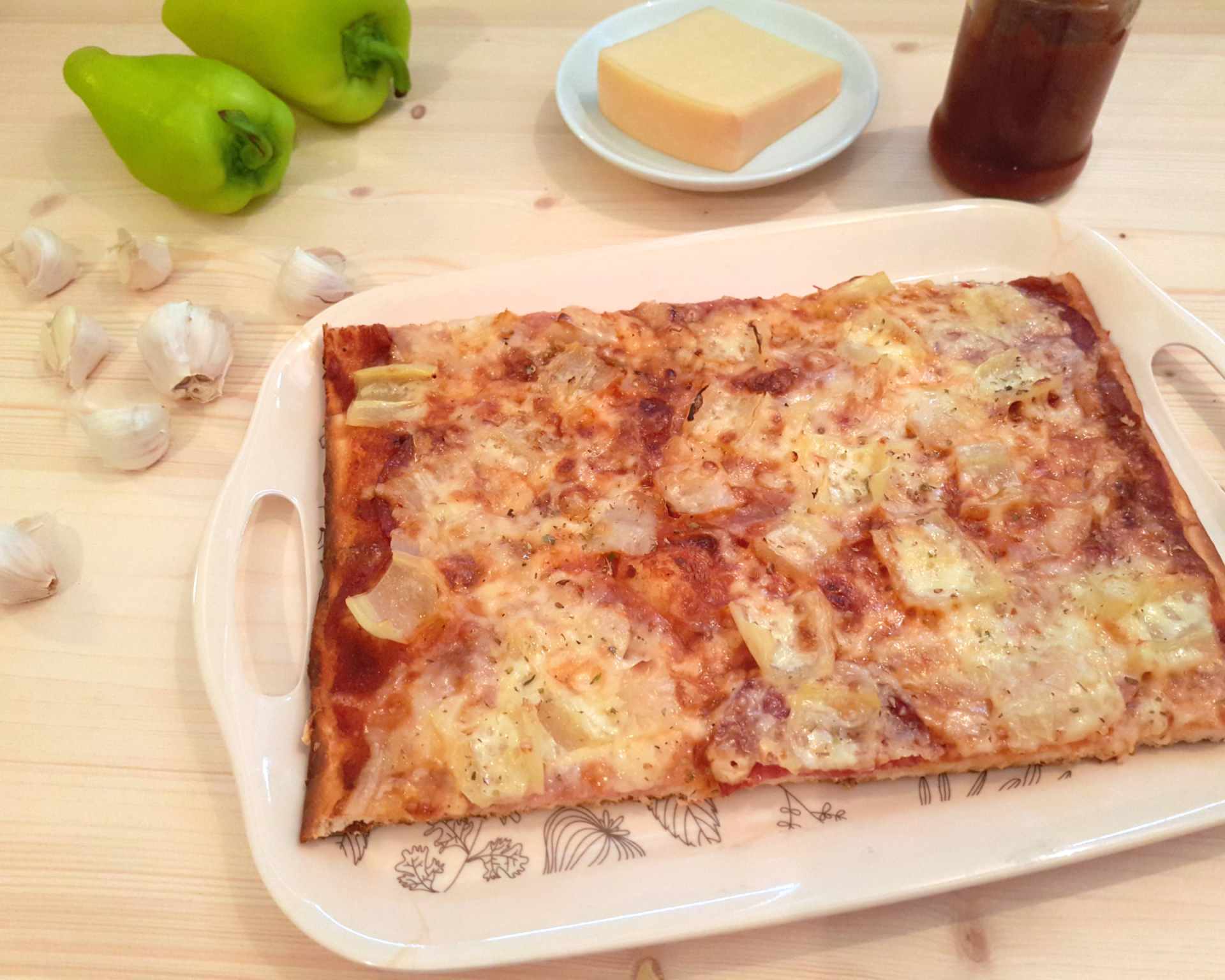 Pizza pečená doma v rúre s paradajkovým základom, saláma, paprika, cesnak, syr mozzarella.