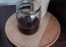 Limonáda z čerešní v sklenenom pohári na drevenej okrúhlej podložke