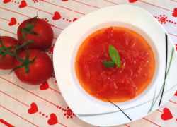 Čerstvé olúpané nakrájané paradajky v červenej polievke ozdobenej bazalkou