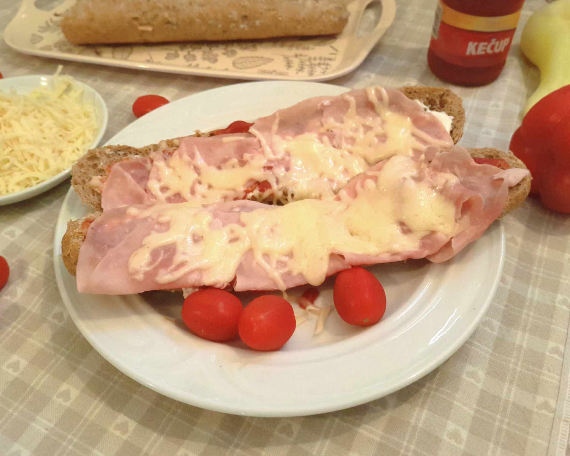 Nádherne vyzerajúca zapekaná celozrnná zdravšia verzia bagetky so šunkou, syrom, kečupom a tatárskou omáčkou