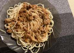 Hotové špagety s mletým mäsom na čiernom priesvitnom tanieri