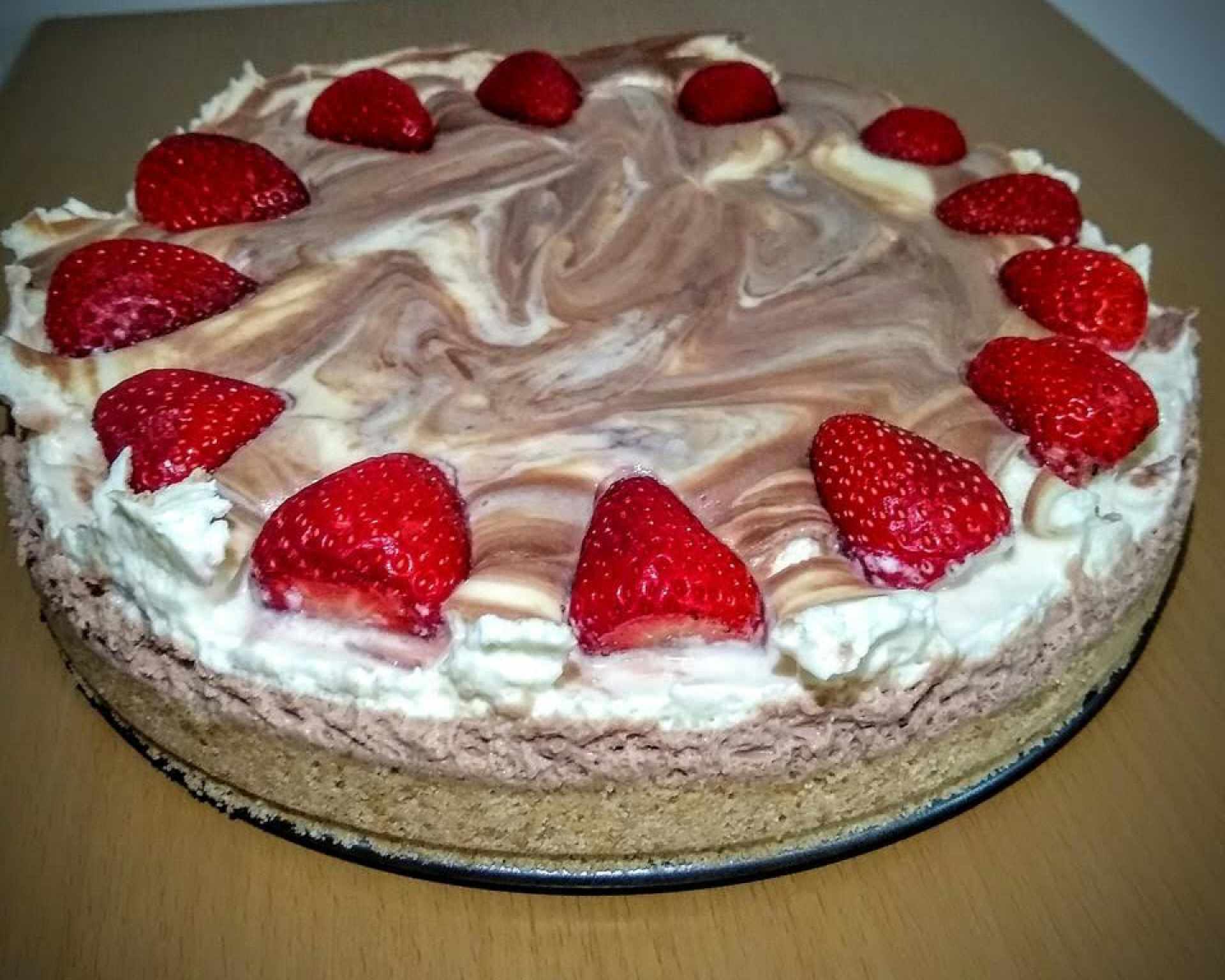 Hotová nepečená nutellová torta so šľahačkou a jahodami