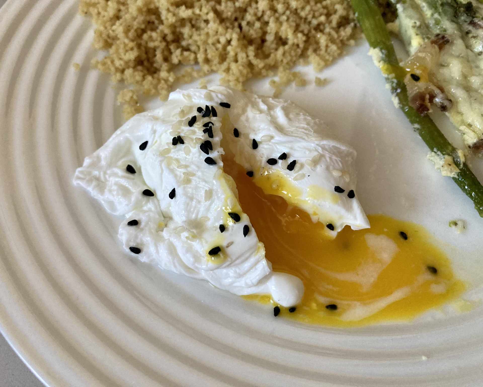 Hotové pošírované vajce posypané bielym a čiernym sezamom