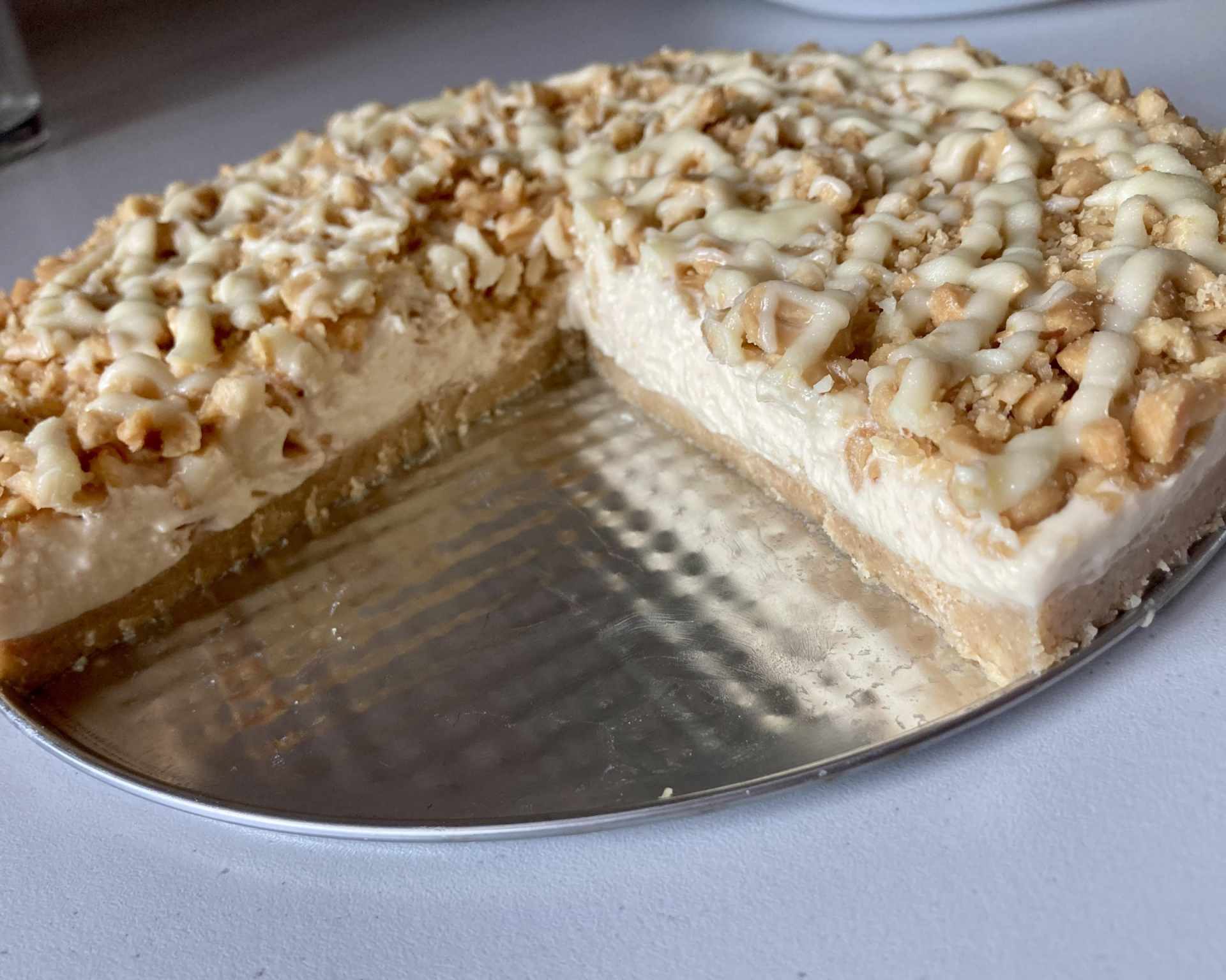 Hotový nepečený arašidový cheesecake posypaný arašidmi