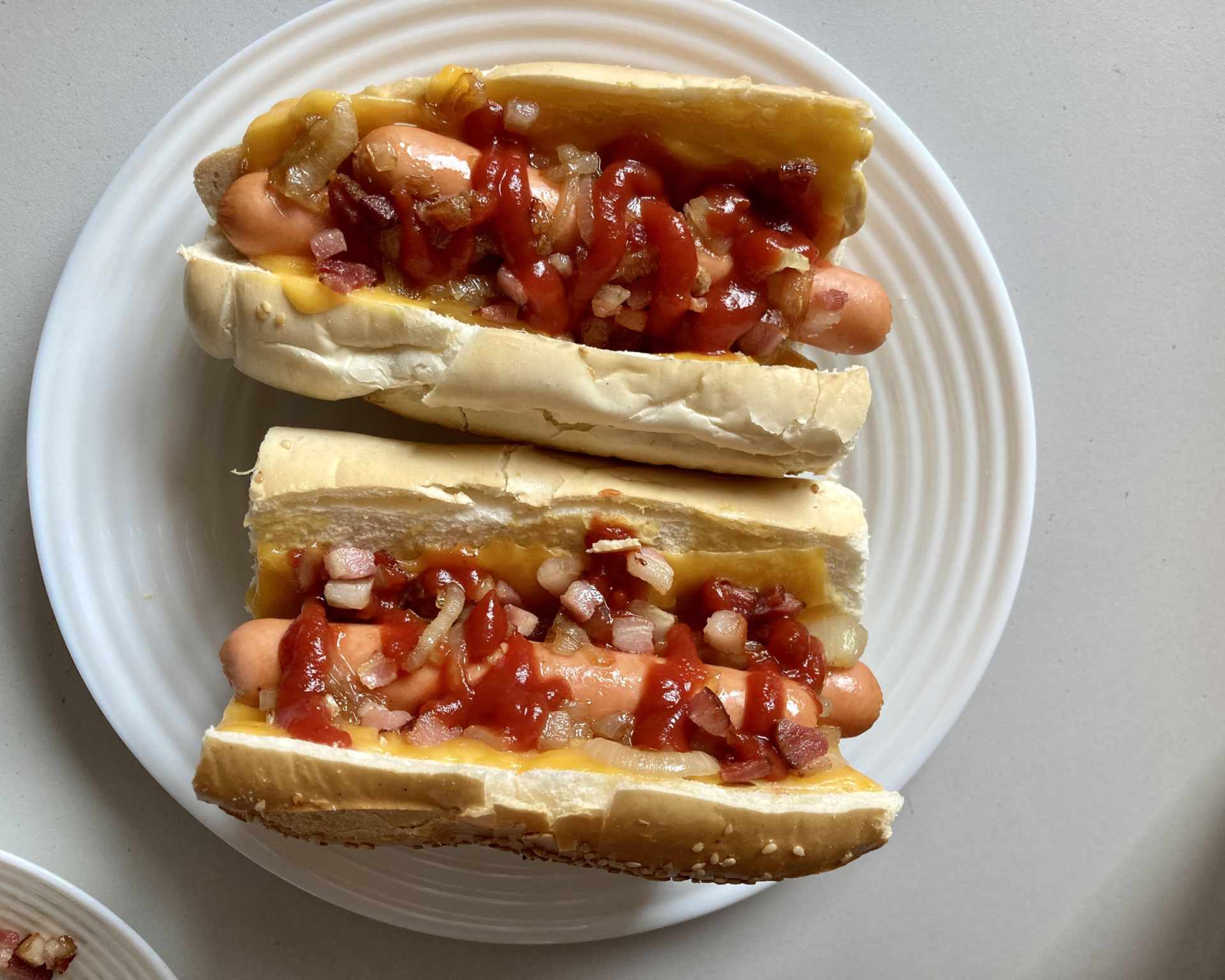 Hotový americký hot-dog s kečupom, slaninou a cibuľou