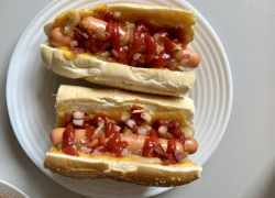 Hotový americký hot-dog s kečupom, slaninou a cibuľou