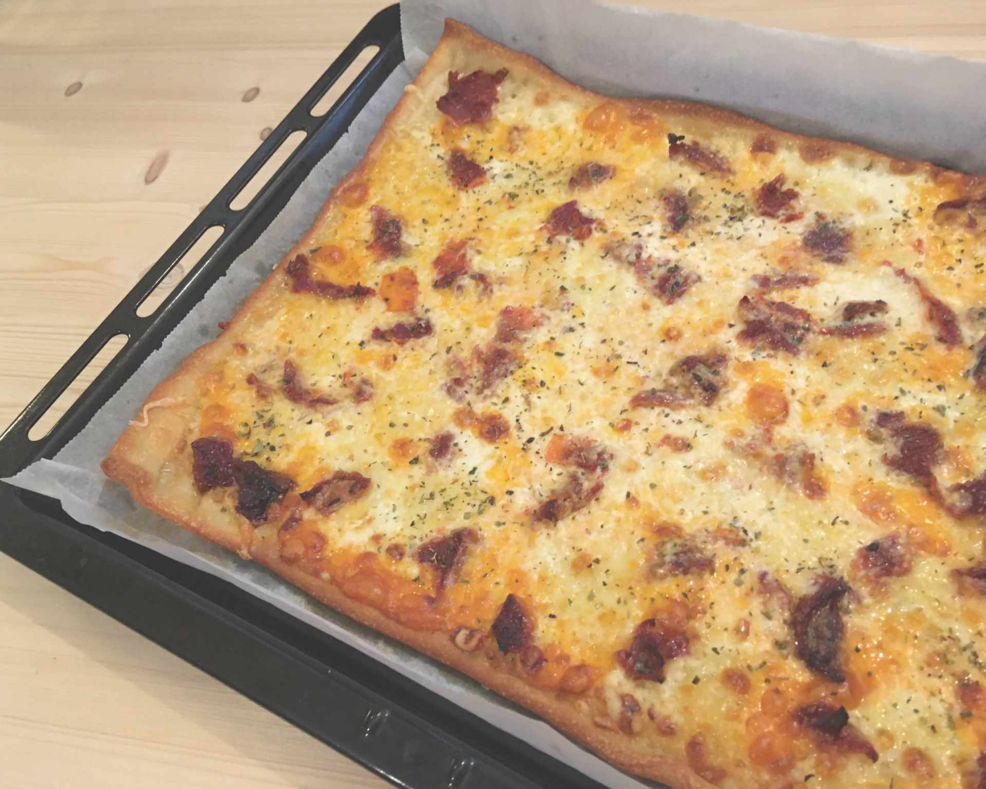 Pizza so smotanovým základom, syr, oregano a sušené paradajky