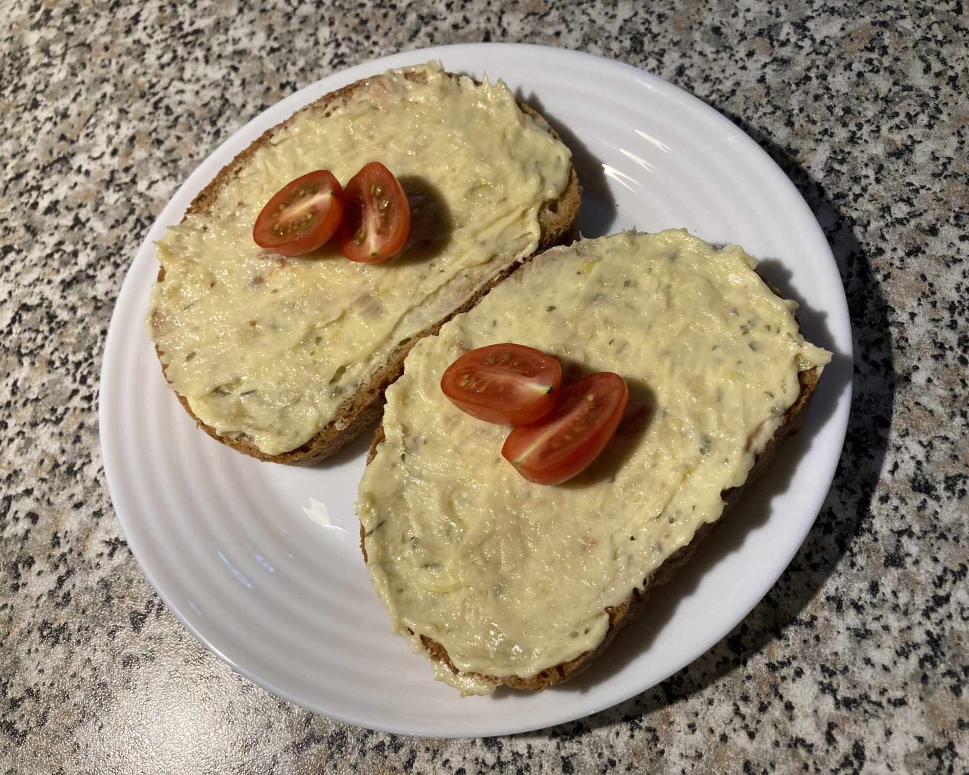 Hotová nátierka z pečeného cesnaku na chlebíku s paradajkami