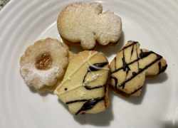 Hotové kokosové linecké koláčiky s lekvárom, posypané cukrom alebo ozdobené čokoládovou polevou