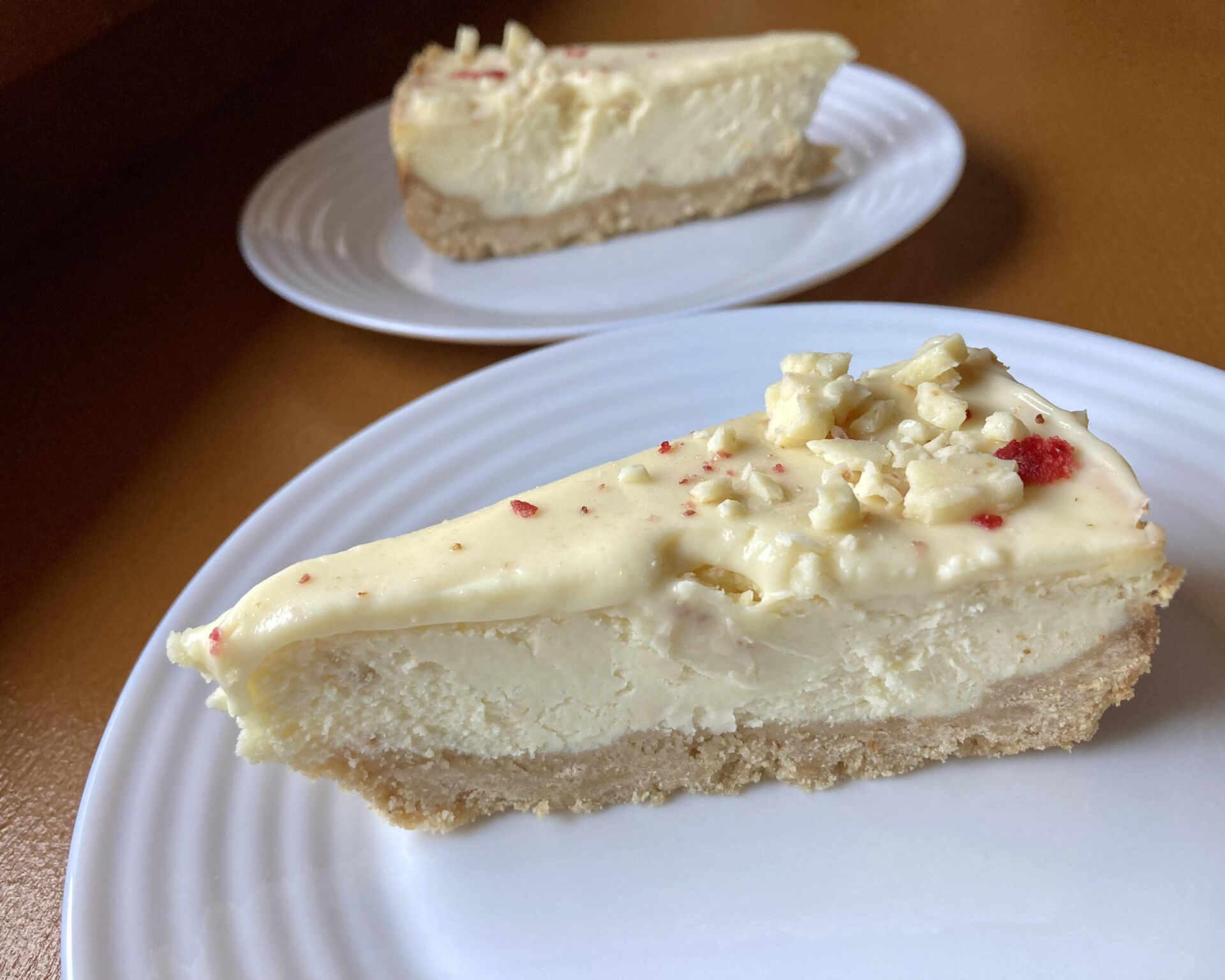 Hotový kokosový cheesecake s polevou z bielej čokolády a sušeným ovocím