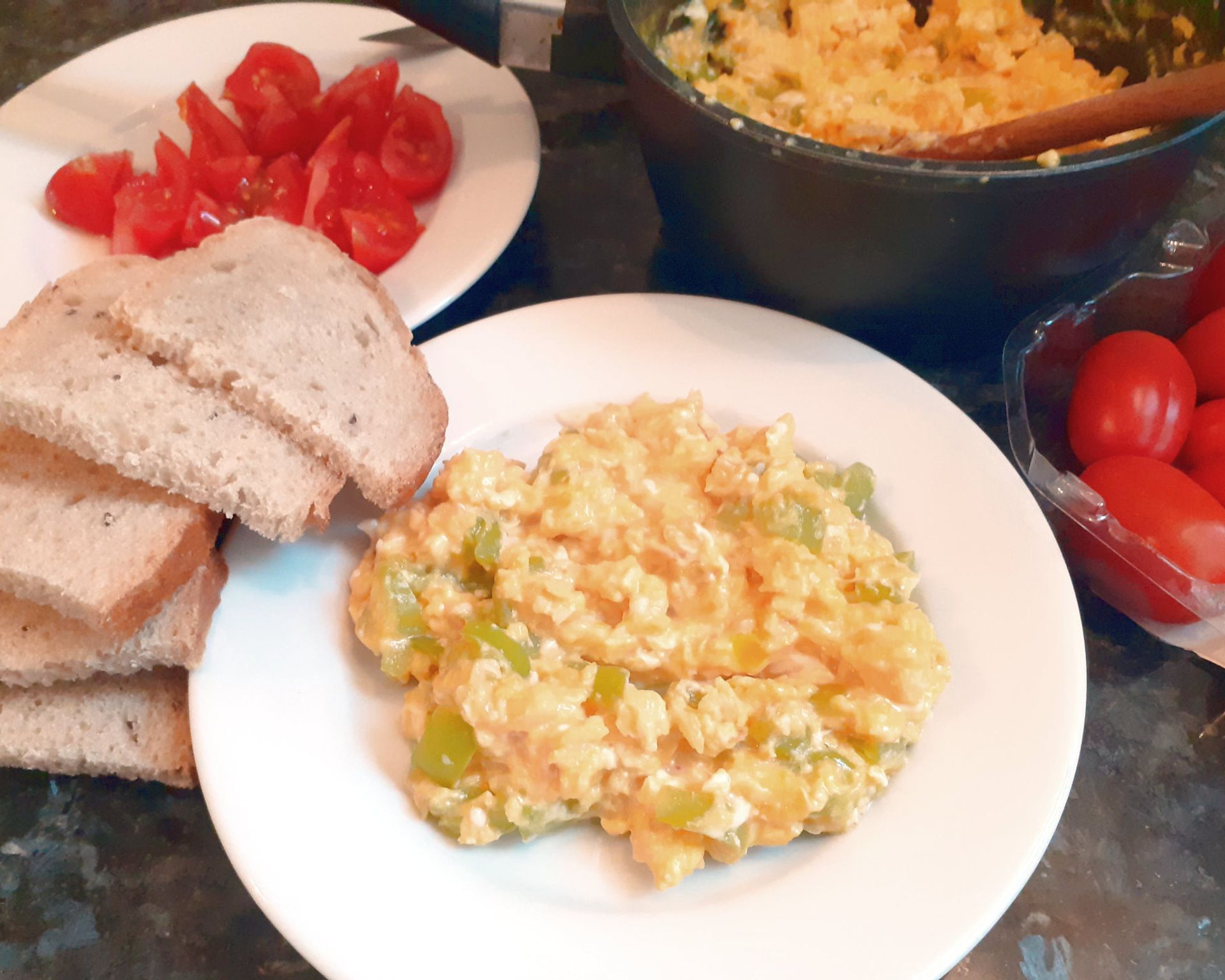 Miešané vajíčka na tanieriku s chlebom a cherry paradajkami