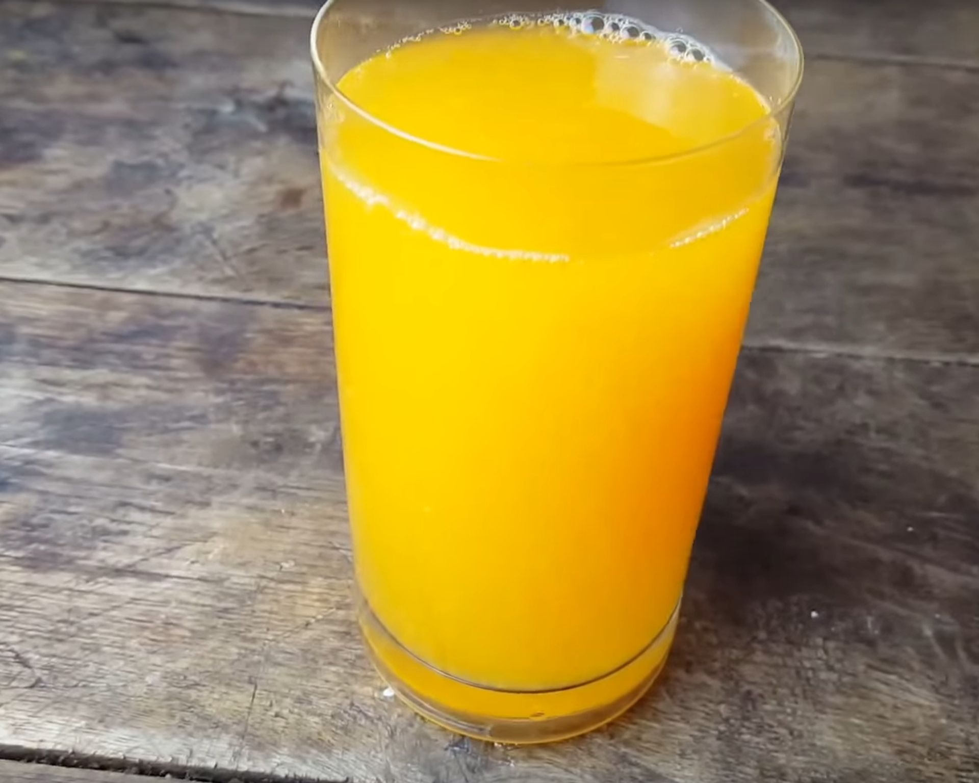 Pomarančový džús v pohári na drevenom stole