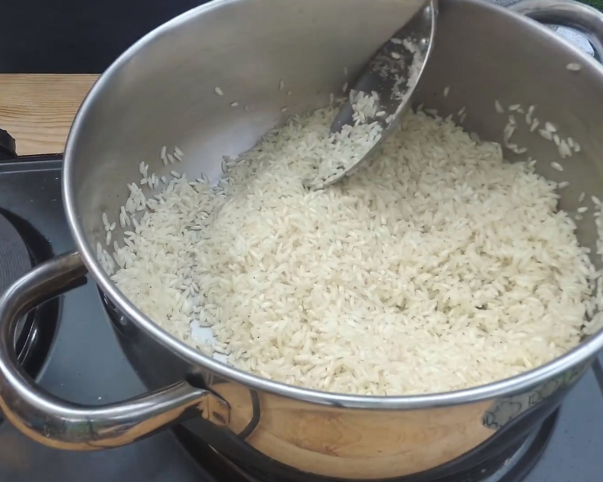 Varená obyčajná biela ryža v nerezovom hrnci na sporáku. Ešte horúca.