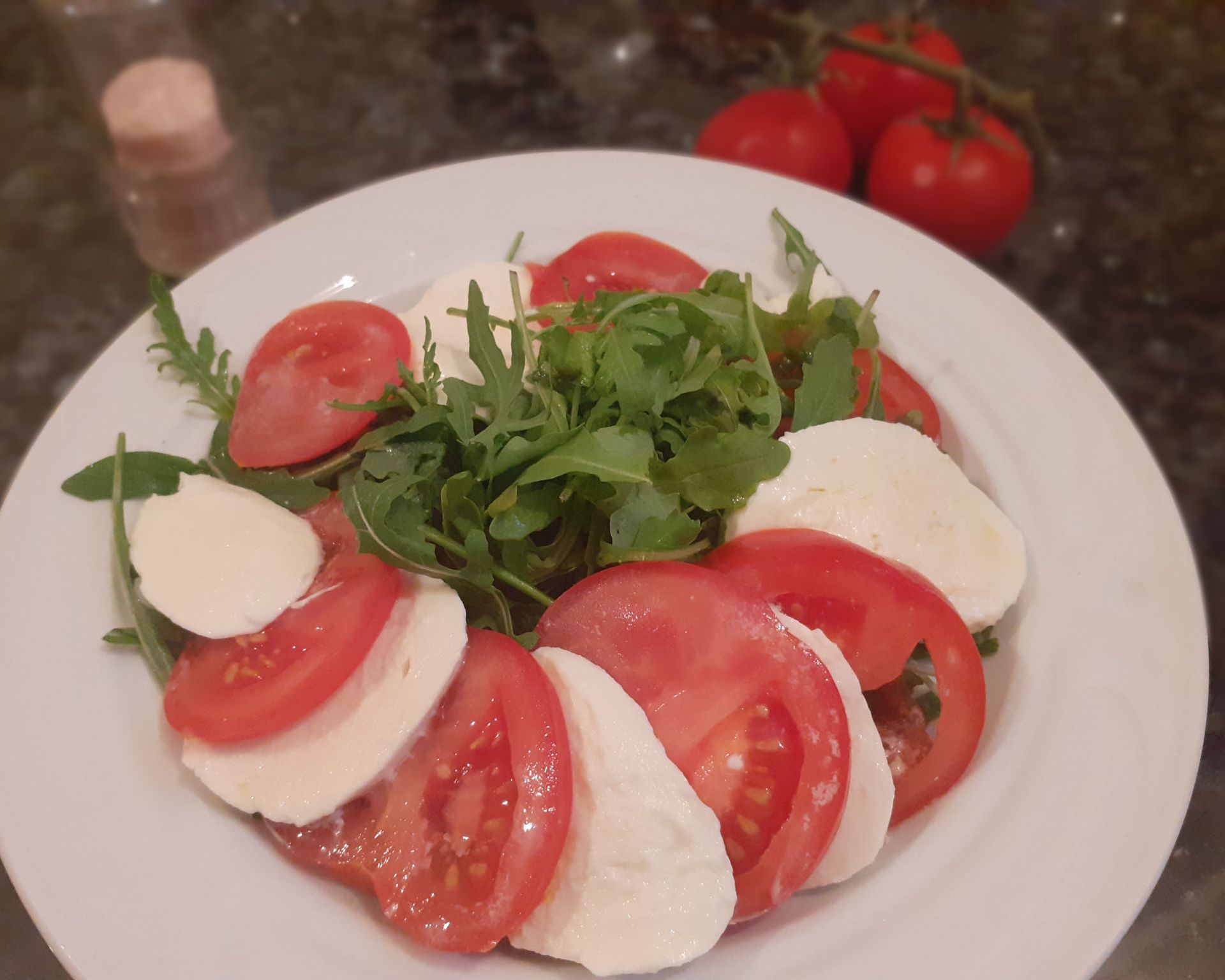 Paradajky a mozzarella na krúžky posypané rukolou