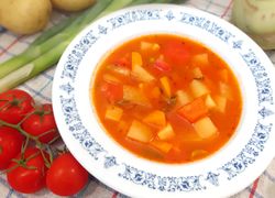 Červená polievka v modro-bielom tanieri so zemiakmi a zeleninou