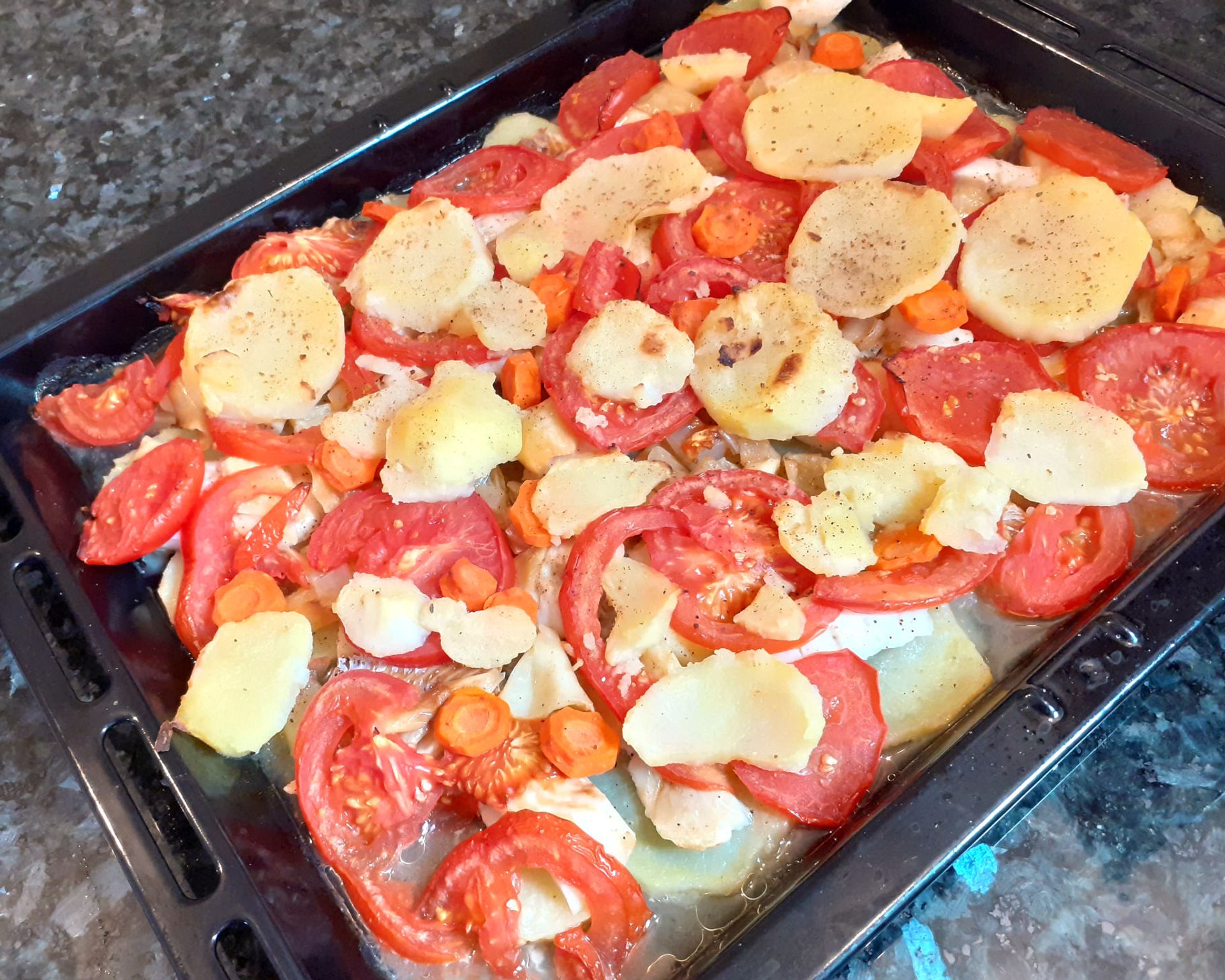Ryba, paradajky, zemiaky, mrkva okorenené, pečené na plechu