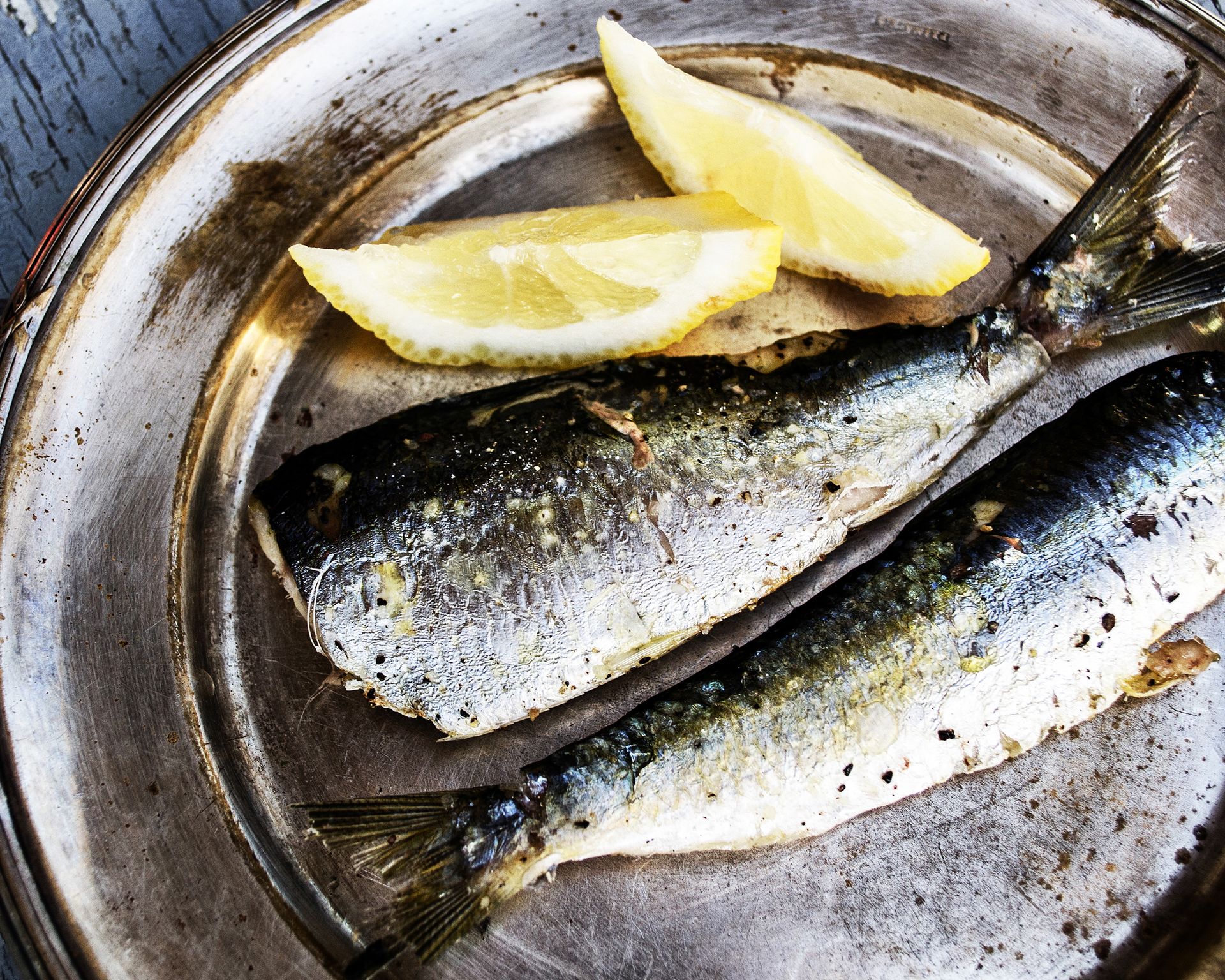 Filety sardiniek v celku. Ugrilované a servírované na keramickom tanieri s citrónom.