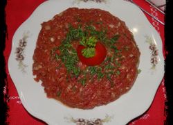 Hovädzí tatarák s cibuľou, v strede taniera paradajka