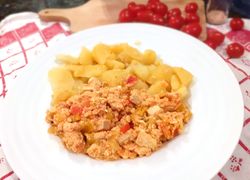 Lečo s tofu a varenými zemiakmi na tanieri v pozadí s cherry paradajkami