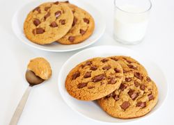 Čokoládové cookies v dvoch porciách. K tomu lyžička arašidového masla a pohár mlieka.