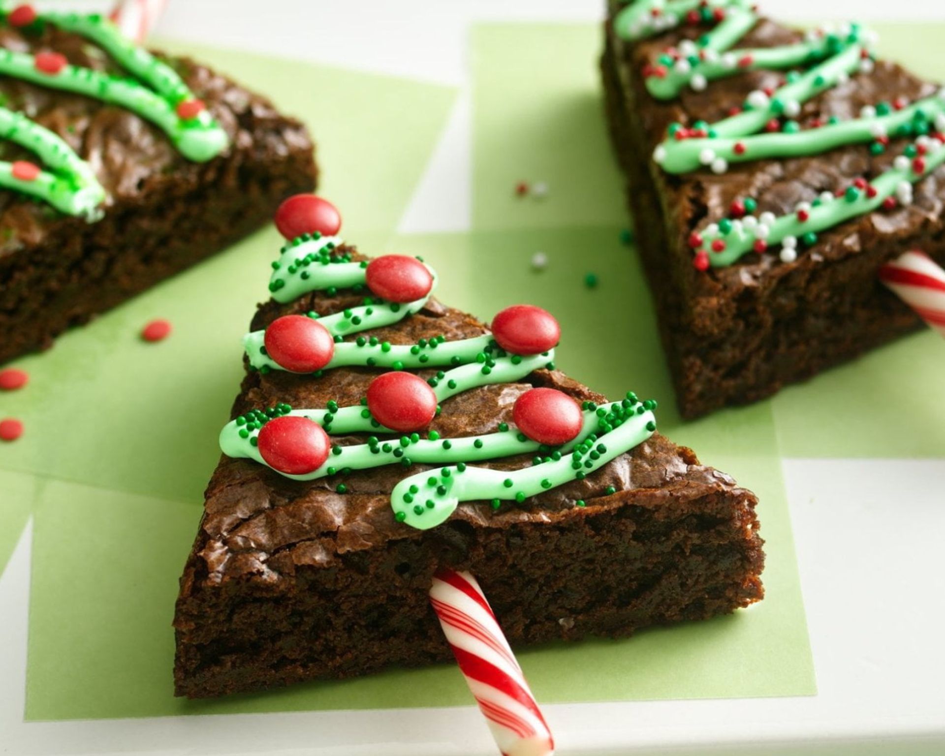 Adventné orechovo-čokoládové brownies v tvare vianočných stromčekov, ozdobené potravinárskym farbivom a červenými lentilkami