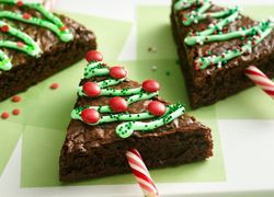 Adventné orechovo-čokoládové brownies v tvare vianočných stromčekov, ozdobené potravinárskym farbivom a červenými lentilkami