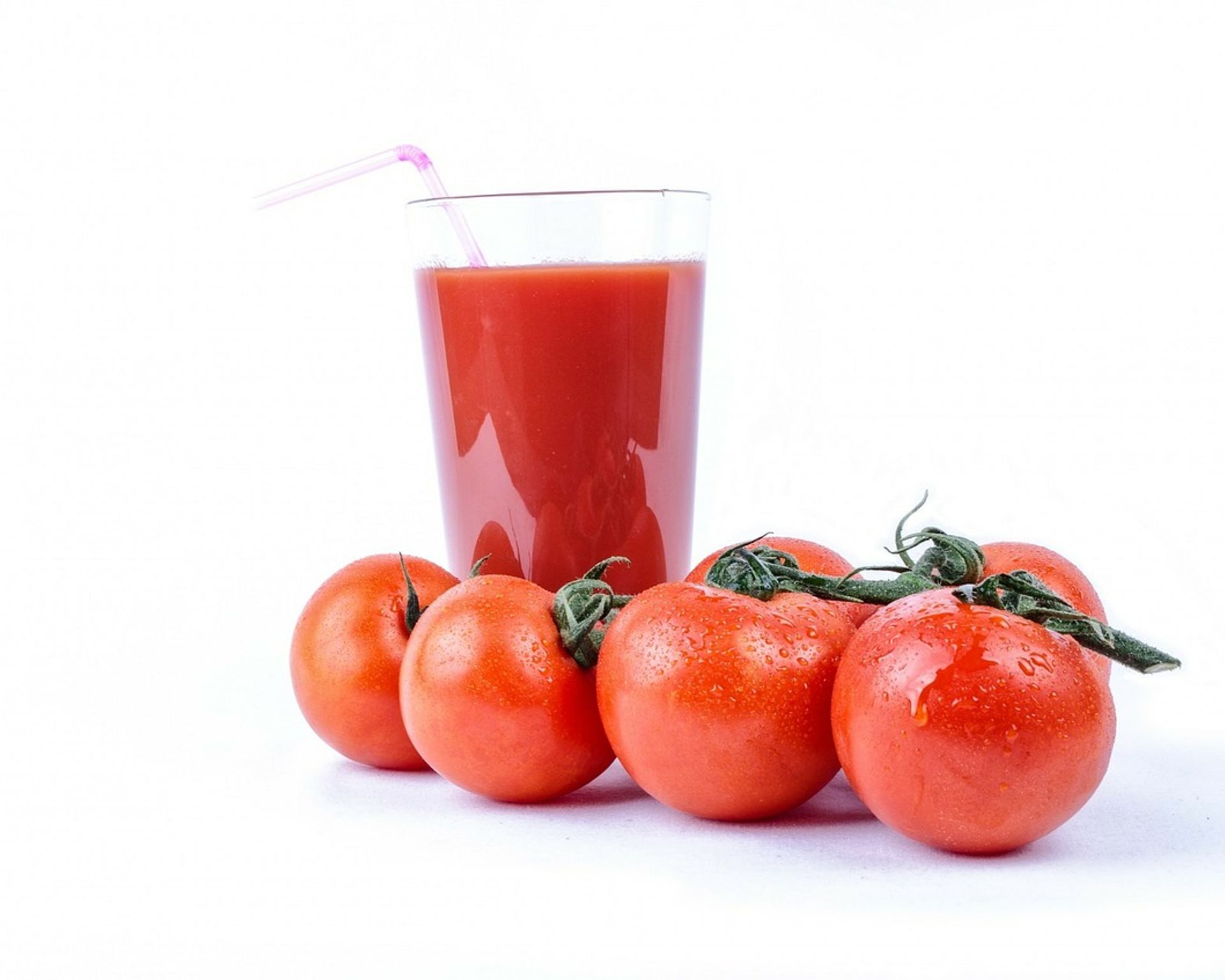 Paradajkové smoothie v pohári, okolo paradajky