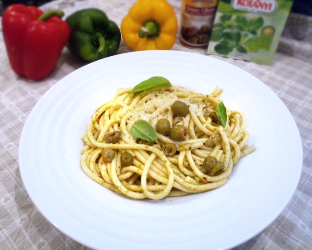 Dlhé tenké cestoviny podobné špagetám, olivy plnené paprikou, lístky bazalky v bielom hlbokom tanieri