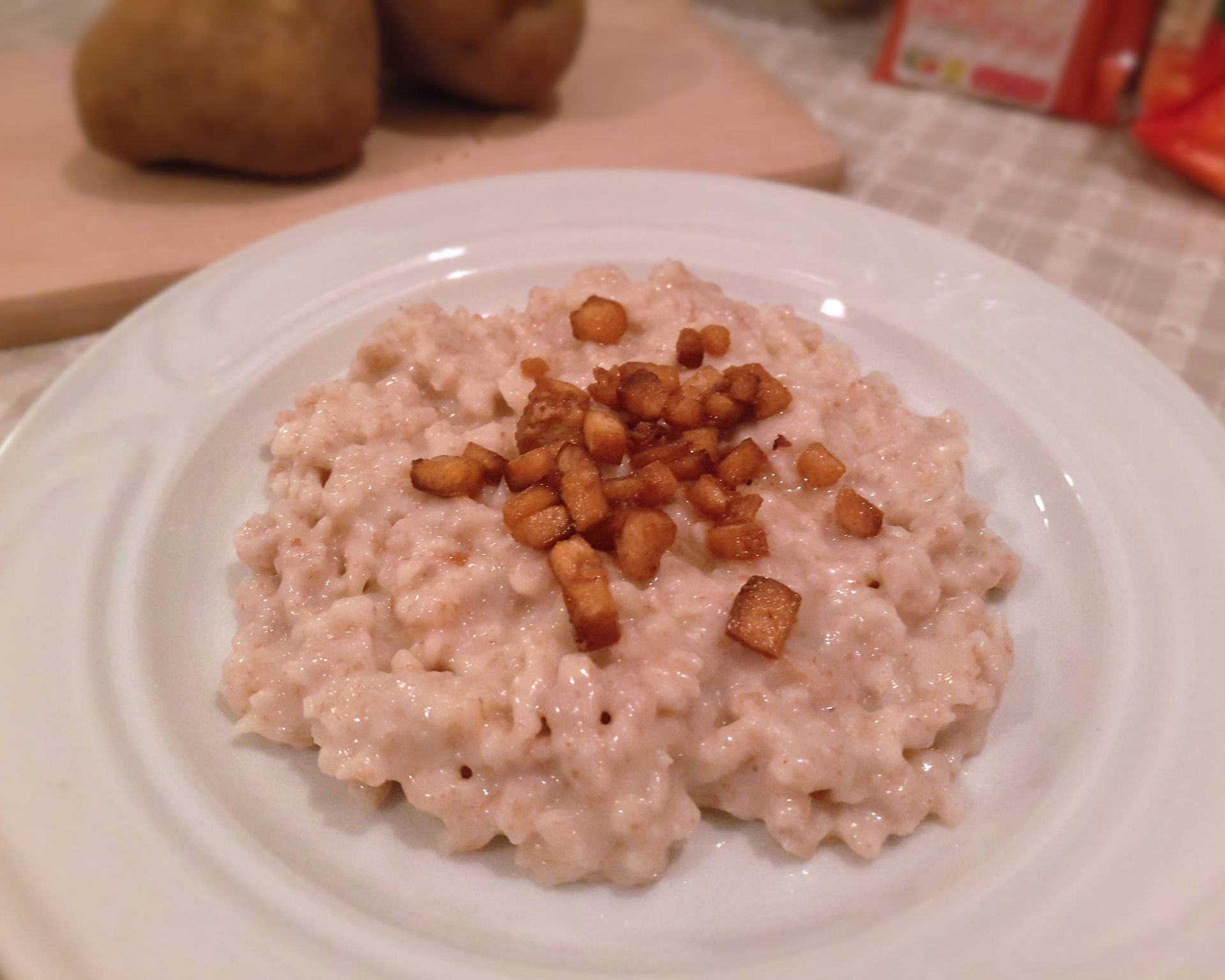 Zemiakové halušky, bryndza, opečené marinované tofu namiesto škvariek, v pozadí zemiaky.