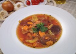 Biely hlboký tanier plný polievky z červenej repy s kalerábom, mrkvou, paprikou a sladkým zemiakom