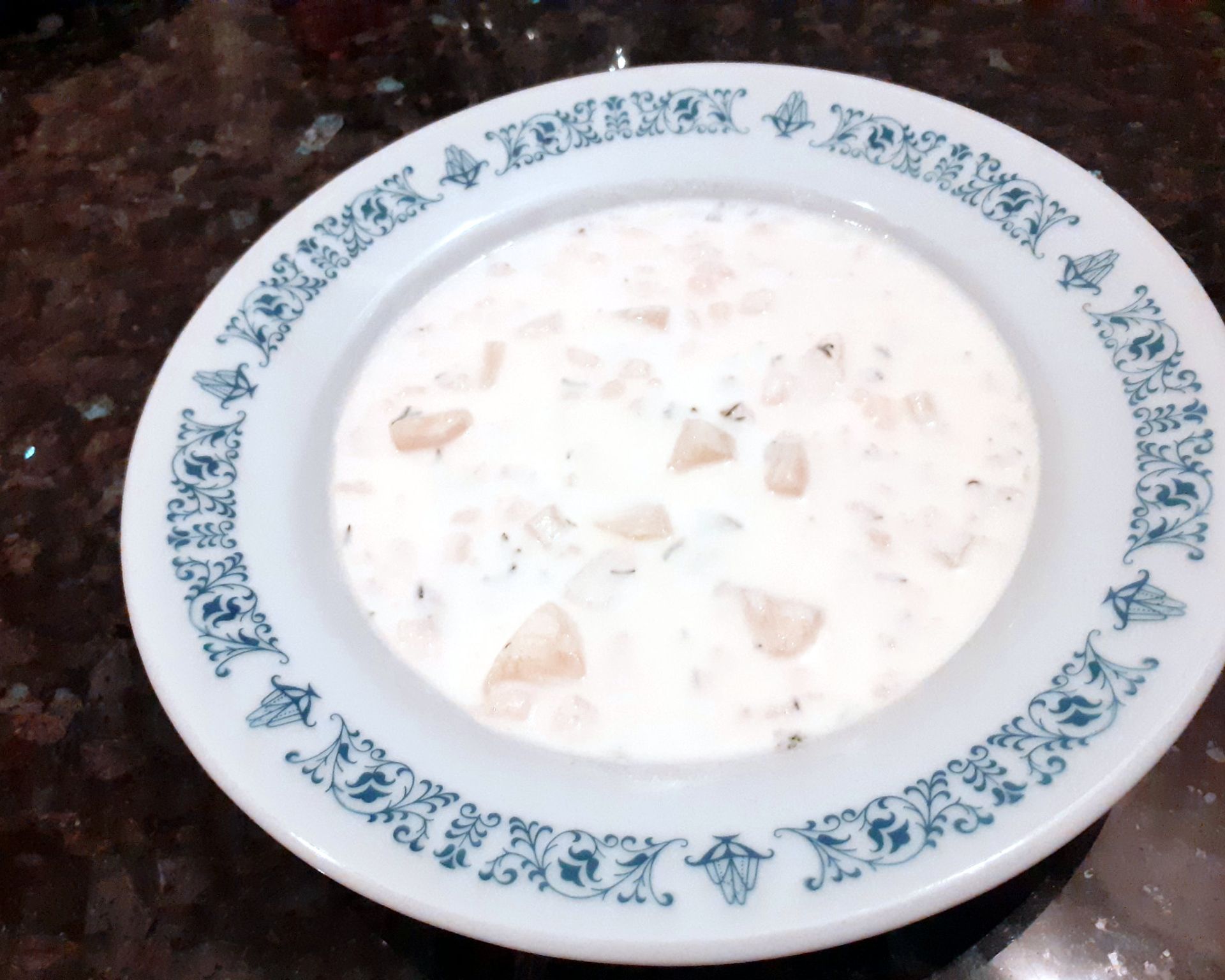 Biely tanier s bielo-modrým okrajom plný mliečnej polievky