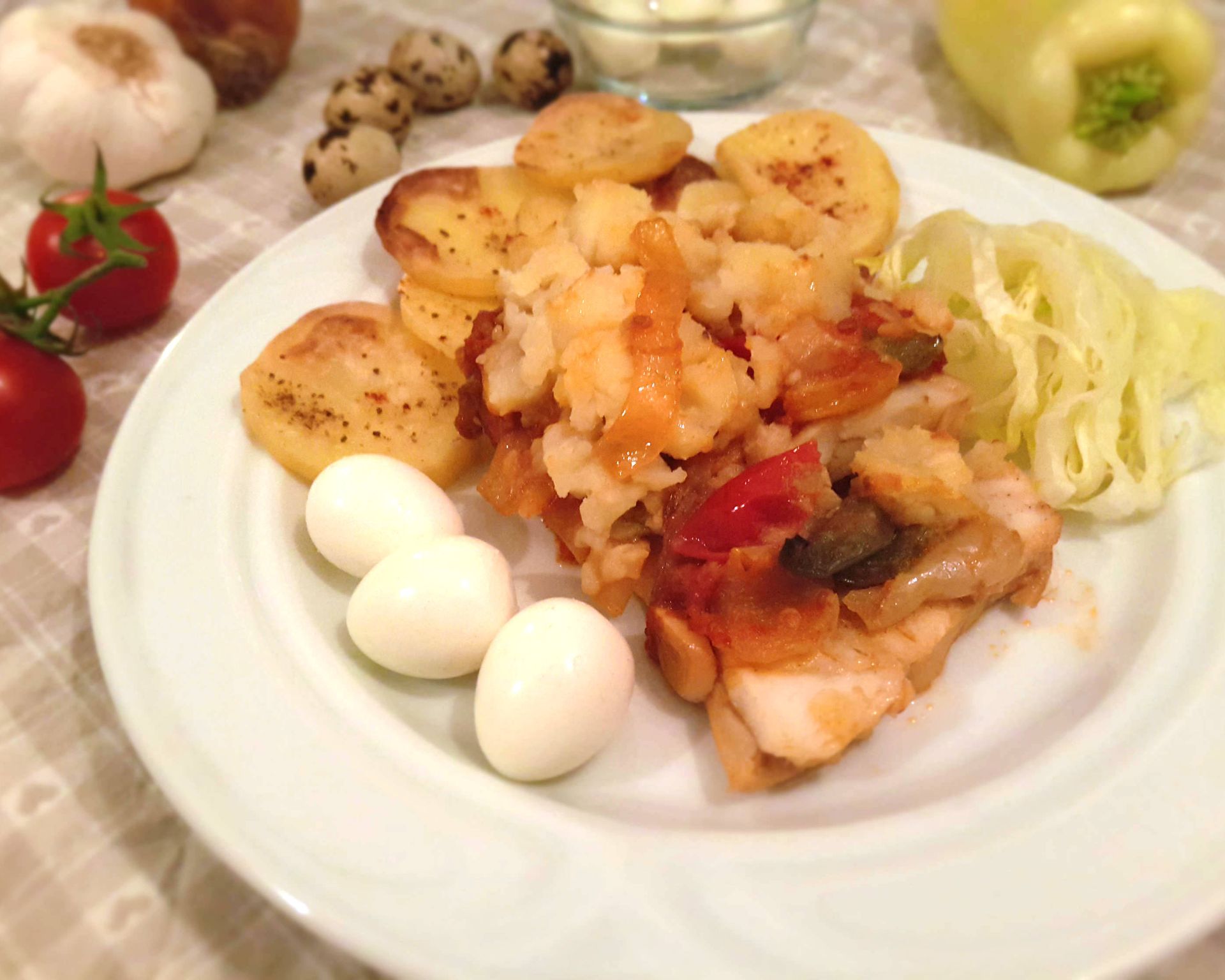 V rúre pečené rybie filety so zemiakovou kašou a zeleninou. Na tanieri ozdobené zeleninou a prepeličími vajciami.