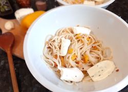 Uvarené cestoviny špagety s praženou paprikou na olivovom oleji. Ako príloha sa podáva syr mozzarella.