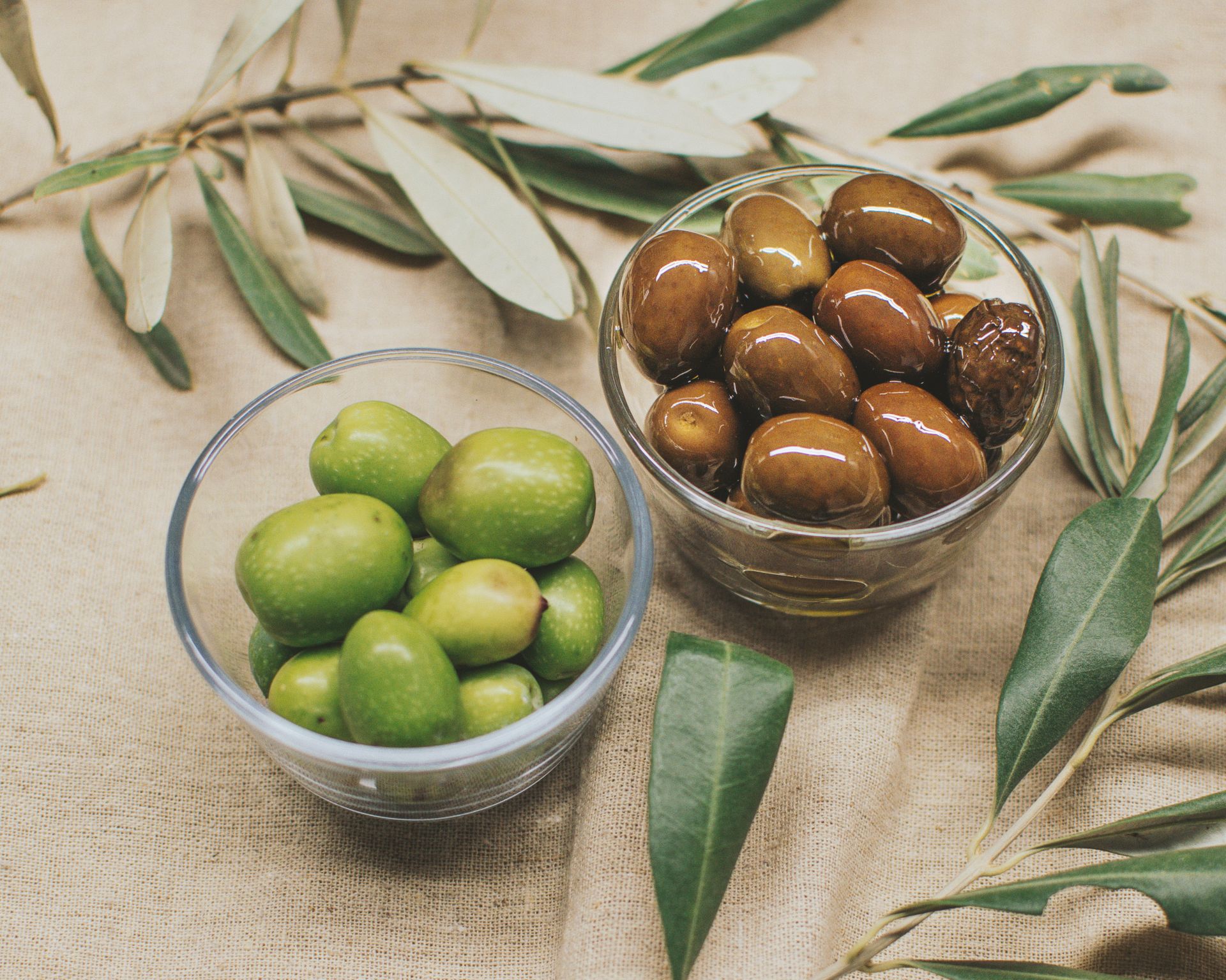 Olivy v sklenených miskách, olivové ratolesti